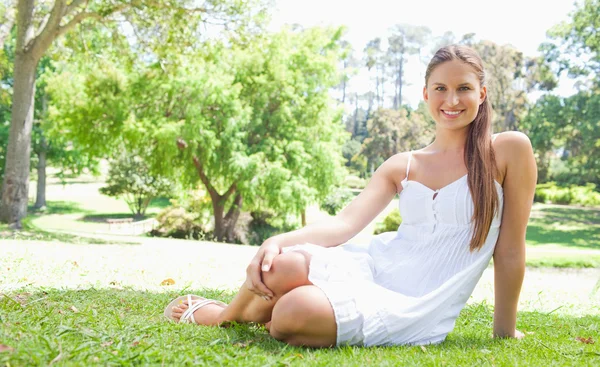 Usmívající se žena uvolňující na trávníku — Stock fotografie