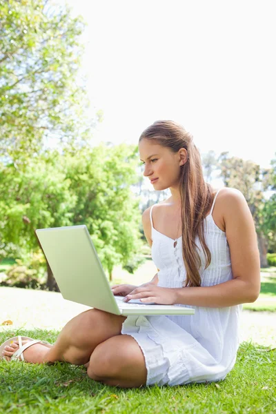 Kvinna på gräsmattan med sin laptop — Stockfoto