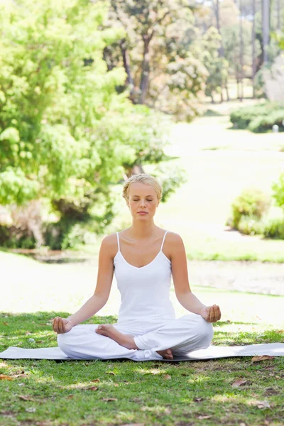 Çimlerde yoga yerinde oturan kadın — Stok fotoğraf