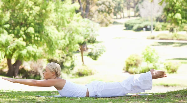 Vista lateral de una mujer haciendo sus ejercicios en el parque —  Fotos de Stock