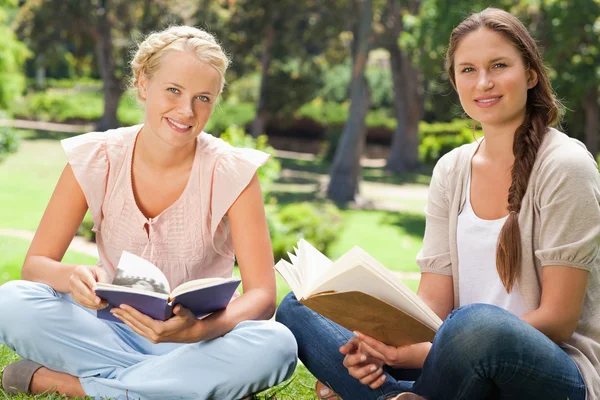 Étudiants assis dans le parc avec leurs livres — Photo