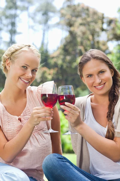 Lachende vrienden rammelende wijnglazen — Stockfoto