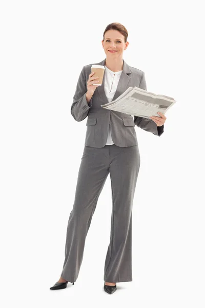 Sorrindo empresária segurando copo e jornal — Fotografia de Stock