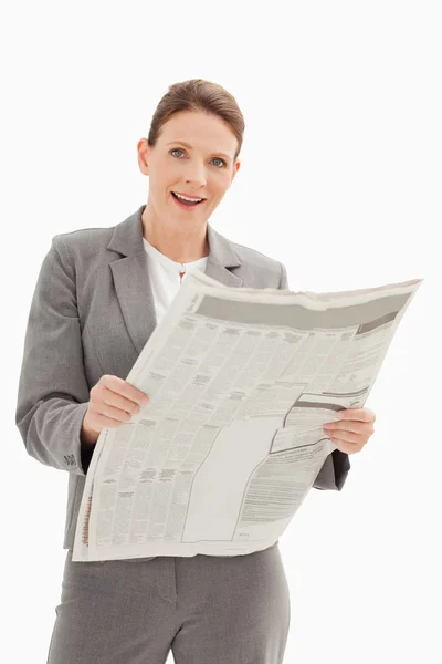 Удивлённая бизнесвумен держит газету — стоковое фото