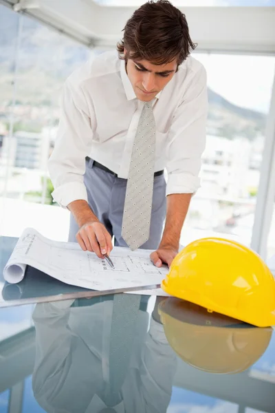 Empresário olhando para desenhos de construção — Fotografia de Stock
