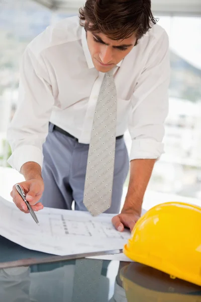 Businessman with blueprints of a building — Stock Photo, Image