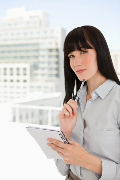 stock image Black haired woman thinks as she looks straight ahead of her