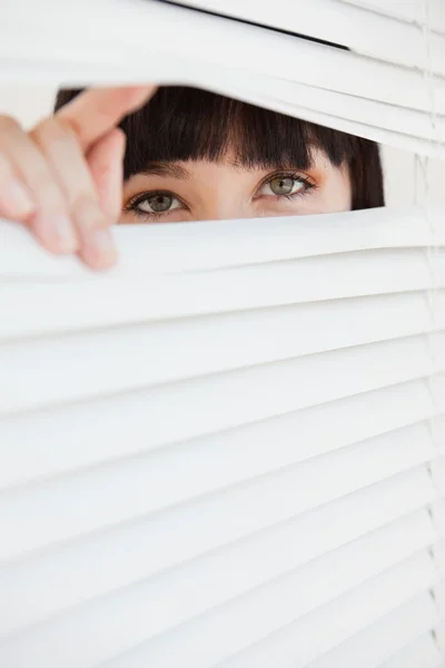 A closed set of blinds with open part opened by a woman — Stock Photo, Image