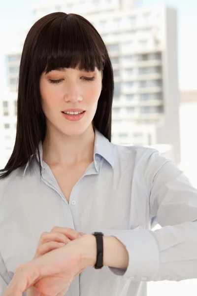 Primer plano de una mujer comprobando la hora de su reloj — Foto de Stock