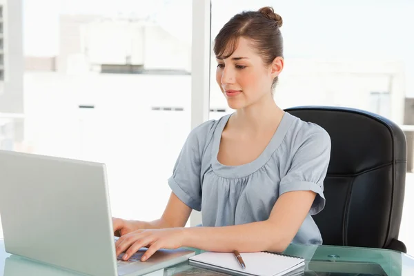 Typy bruneta zaměstnanců na svém laptopu — Stock fotografie