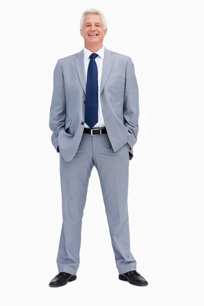 Portret van een glimlachende zakenman met zijn handen in zijn zakken — Stockfoto