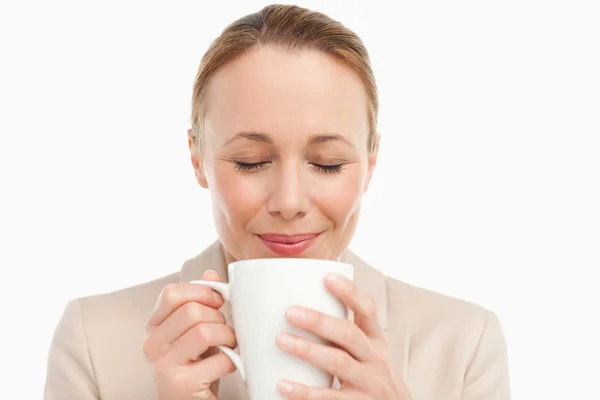 Kvinna i en kostym att lukta henne te — Stockfoto