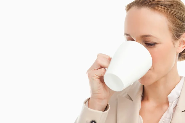 Vrouw in een pak een kopje koffie drinken — Stockfoto