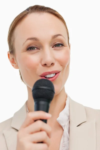 Πορτραίτο μιας γυναίκας σε ένα κοστούμι μιλώντας με ένα μικρόφωνο — Φωτογραφία Αρχείου