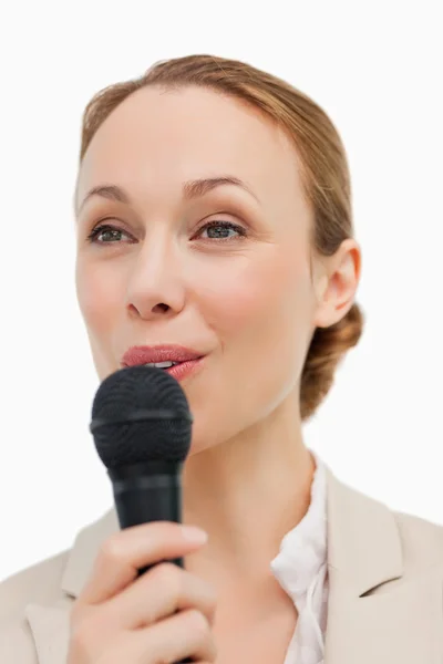Mulher de fato a falar com um microfone — Fotografia de Stock