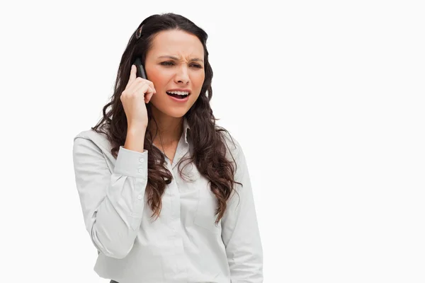 Close-up of a brunette grimacing on the phone — Stock Photo, Image