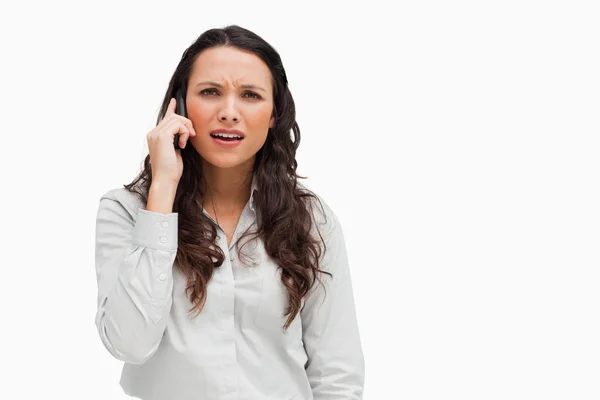 Close-up of a brunette grimacing while phoning — Stock Photo, Image