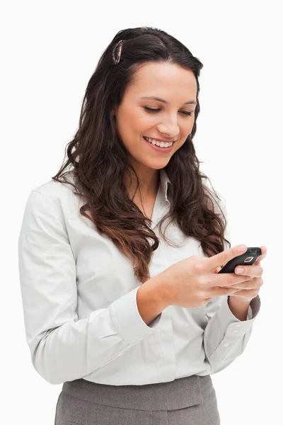 Morena sonriendo mientras mira su mensaje de texto —  Fotos de Stock