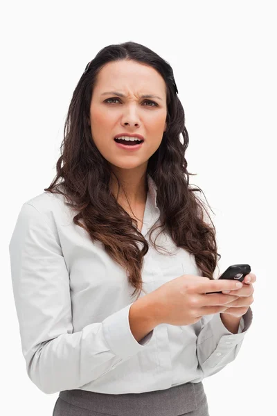 Portrait d'une brune grimaçant en regardant son message texte — Photo