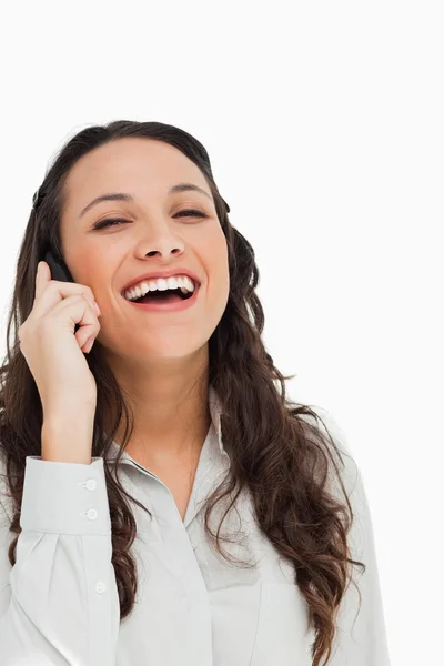 Porträtt av en ganska brunett skrattar medan ringa — Stockfoto