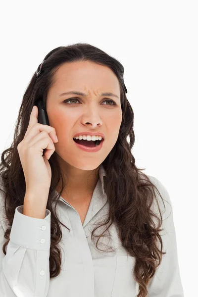Portret van een brunette grimassen terwijl telefoneren — Stockfoto