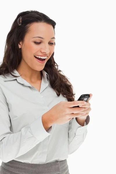 Brunette beaming while using her mobile — Stock Photo, Image