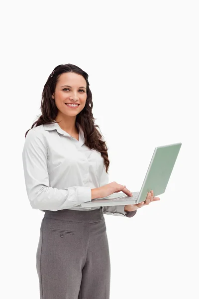 Retrato de uma morena de pé enquanto usa um laptop — Fotografia de Stock