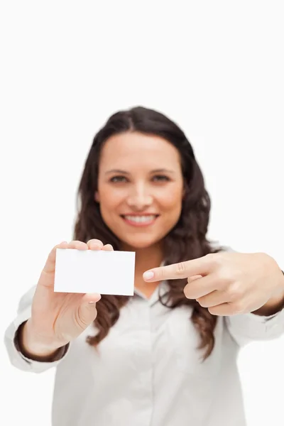 Morena mostrando e apontando um cartão — Fotografia de Stock
