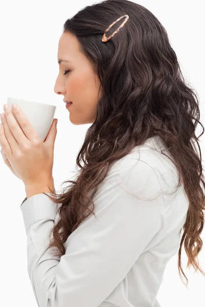 Profiel van:: een brunette ruiken een warme koffie — Stockfoto