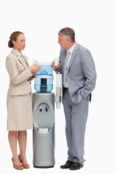 stock image in suit talking next to the water dispenser