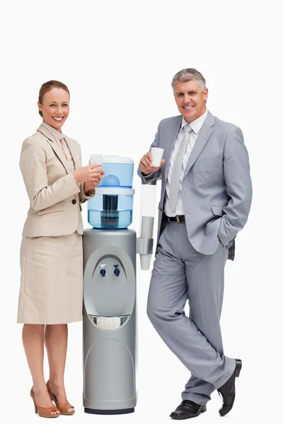 stock image Portrait of business smiling next to the water dispenser