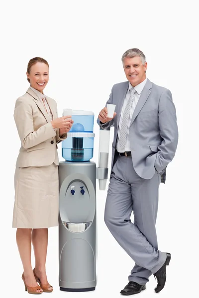 stock image Portrait of smiling business next to the water dispenser