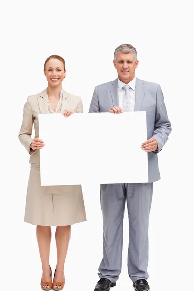 Unternehmen lächeln, während sie ein Plakat in der Hand halten — Stockfoto