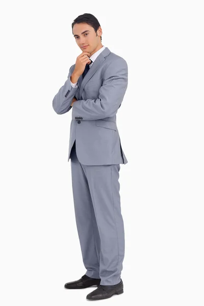 Thoughtful businessman smiling with folded arms — Stock Photo, Image
