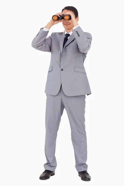 Businessman smiling while using binoculars — Stock Photo, Image