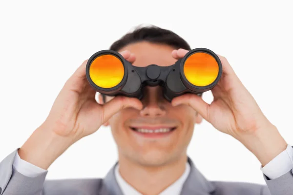 Primer plano de un hombre de negocios sonriente usando prismáticos — Foto de Stock