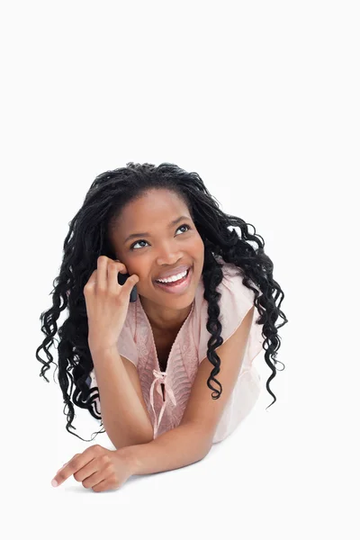 A young girl talking on the mobile phone is looking up — Stock Photo, Image