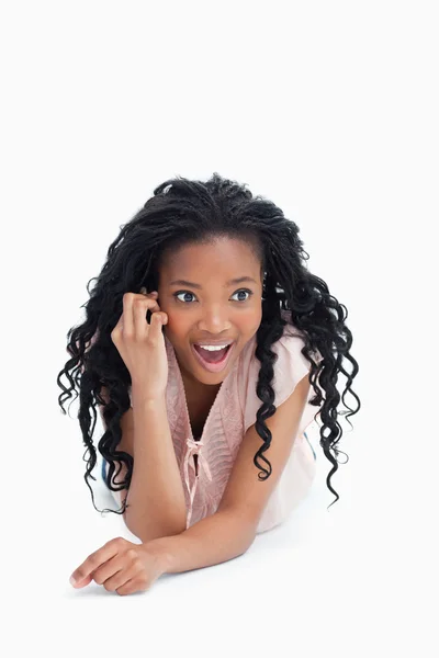 Uma visão frontal de uma jovem garota surpreso falando em seu mobil — Fotografia de Stock