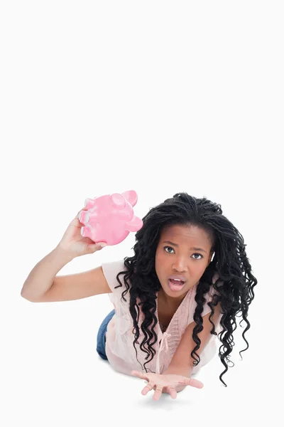 一个担心的年轻女人，抱着空的存钱罐 — 图库照片
