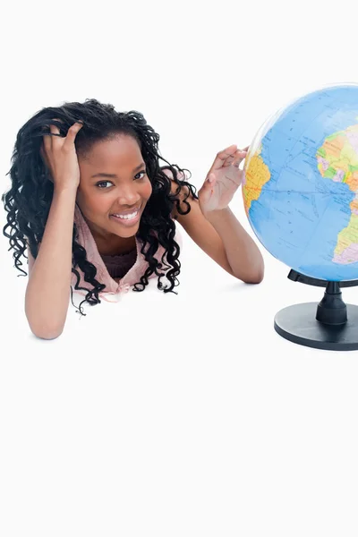 A young girl with her and on a globe — Stockfoto