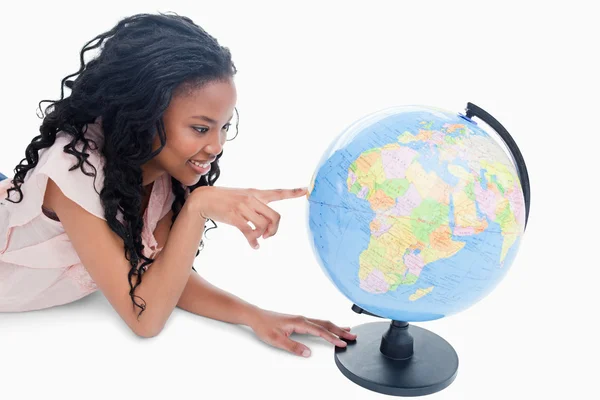 A young girl is pointing at a globe — Stock Photo, Image
