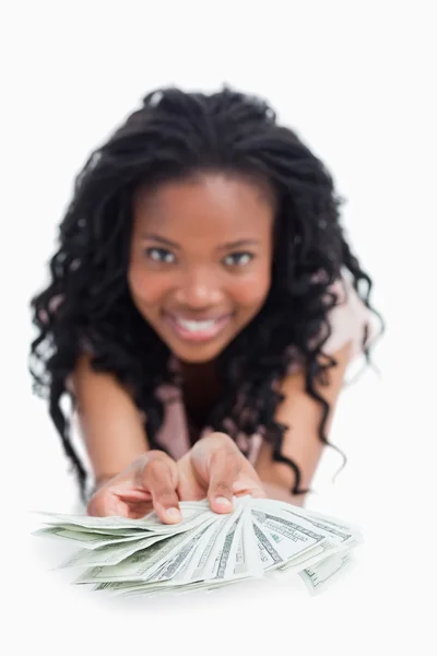 stock image A smiling woman is holding American dollars out in front of her