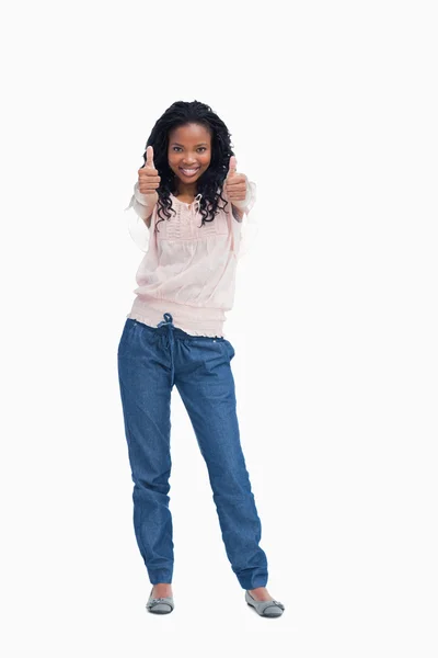 A smiling woman is standing with her thumbs up — Stock Photo, Image