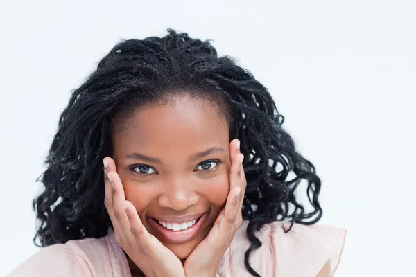 stock image Head shot of a smiling young woman holding her head in her hands