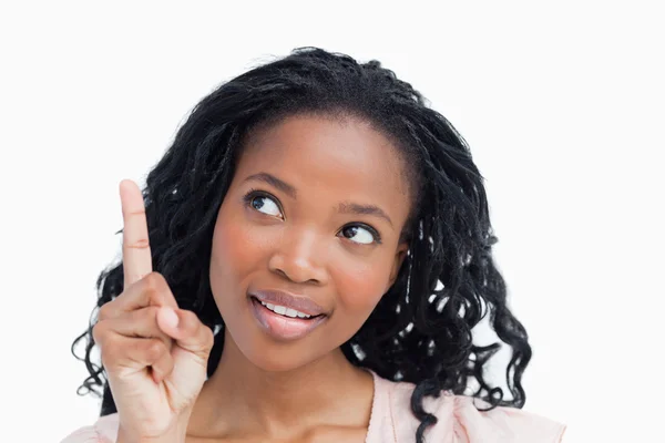 Head shot of a happy young woman with her finger held up — Stock Photo, Image