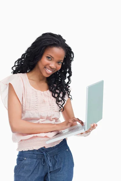 Bir laptop tutan genç bir kadın kameraya gülümseyen — Stok fotoğraf