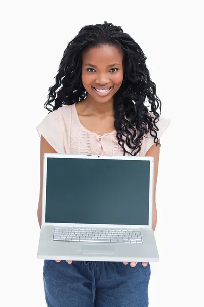 Una joven está sosteniendo un portátil frente a ella. — Foto de Stock