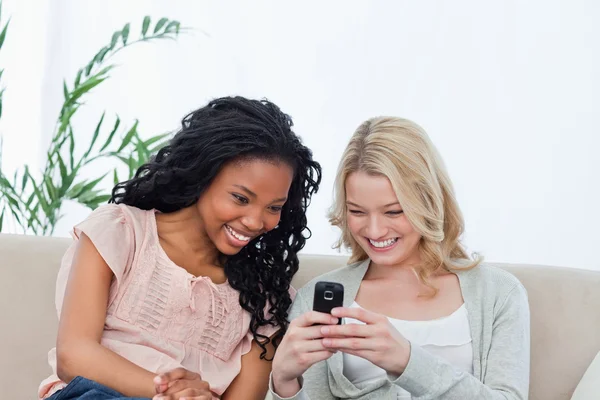 En kvinna visar sin vän sin mobiltelefon — Stockfoto