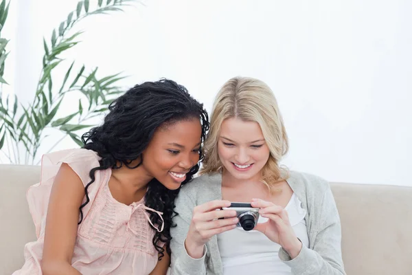 Dos mujeres miran fotos en una cámara digital — Foto de Stock