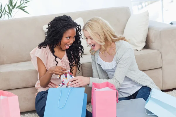 Twee vrouwen kijken naar kleren in shopping tassen — Stockfoto